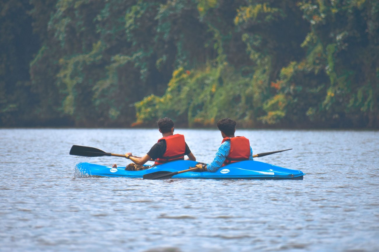 Two paddlers in a kayak on the still water of Mida Creek