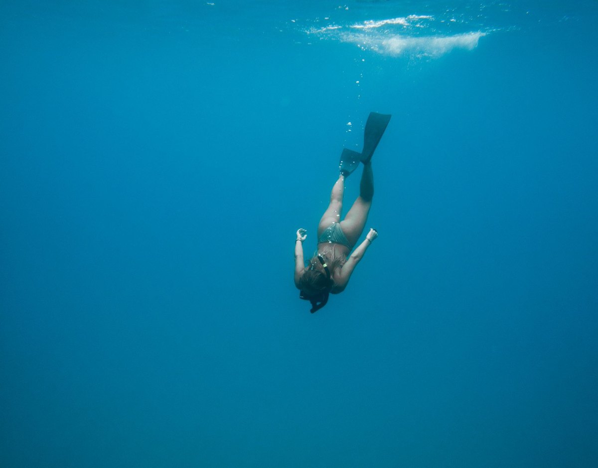 Freediver descending into clear blue water