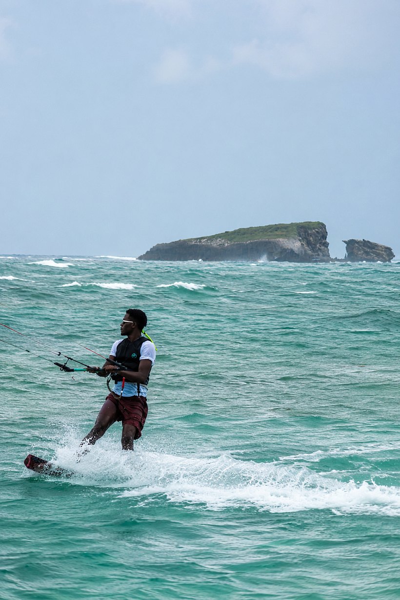Zonjee riding a kiteboard at Watamu, with the offshore island behind him